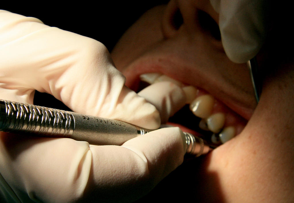 A picture of a dentist probing a mouth.